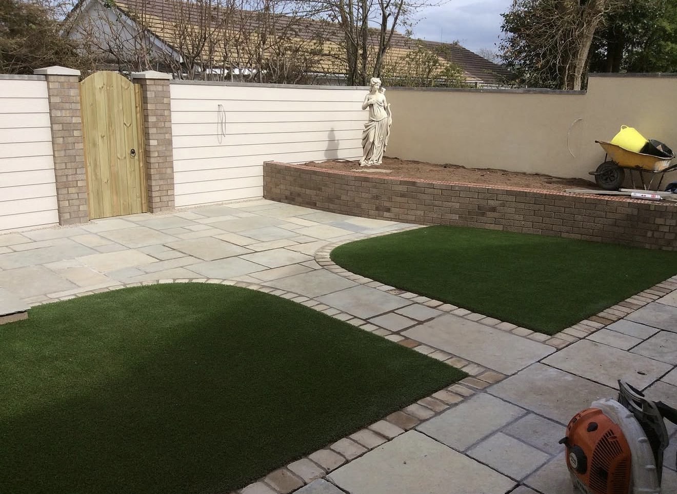 Garden landscaping with artificial grass and natural stone paving