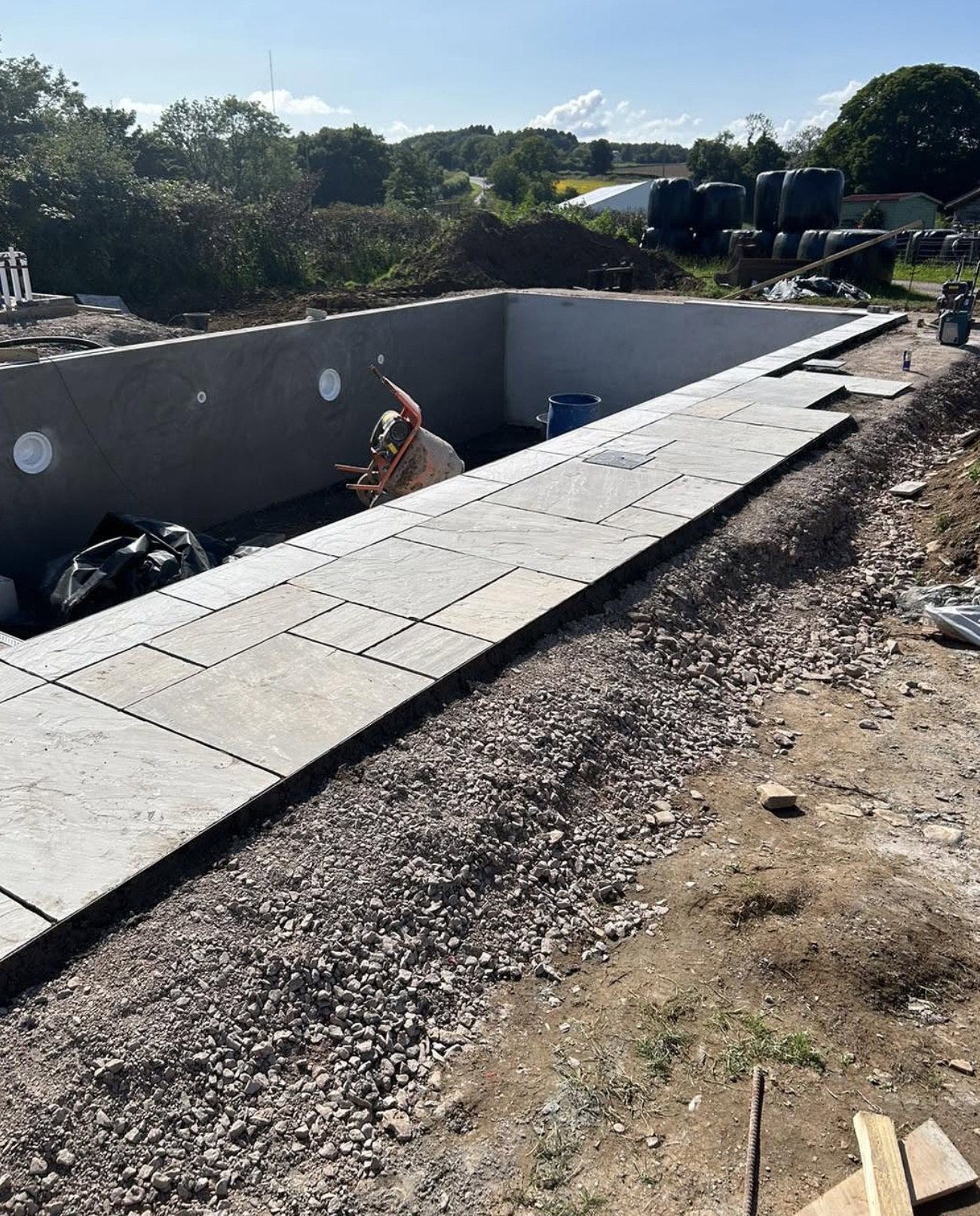 Swimming pool construction with natural stone surround